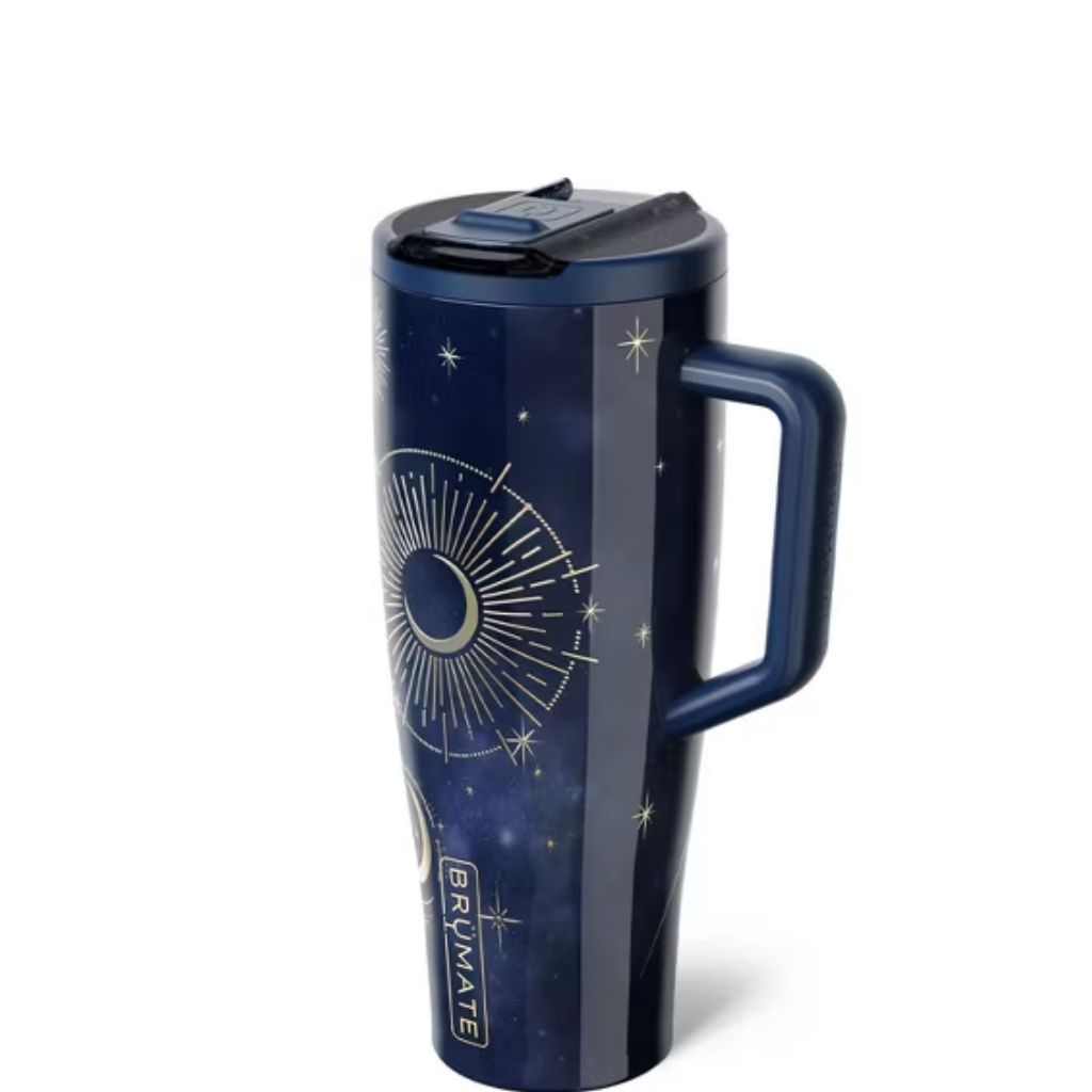 BrüMate Starfall tumbler featuring a midnight navy blue galaxy-inspired background, gold crescent moon with radiant sunburst detailing, scattered celestial stars, and matching dark blue lid and handle
