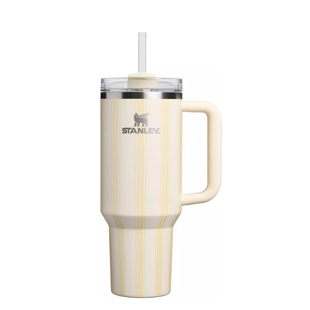 Stanley Cream Picnic Stripe tumbler featuring a warm ivory-cream finish with delicate buttery-yellow and champagne vertical pinstripes, matching cream handle and straw topper, clear lid, silver Stanley logo, and stainless steel rim.
