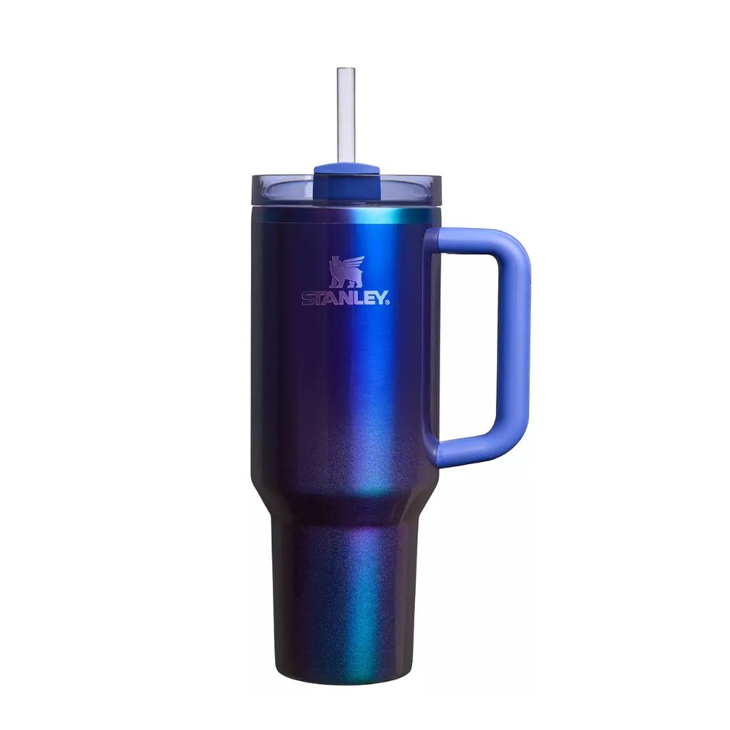 Stanley Starshine tumbler with reflective metallic midnight purple, electric cobalt blue, indigo, and teal color-shifting finish, periwinkle-blue handle and straw topper, smoky translucent blue lid, and silver Stanley logo.